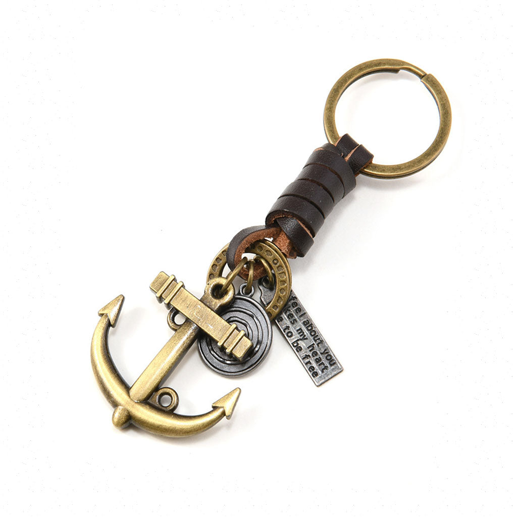 A vintage anchor keychain made of handwoven genuine brown leather cord, featuring an antique bronze anchor pendant, a round metal charm, and a rectangular plaque engraved with the phrases "I feel about you"