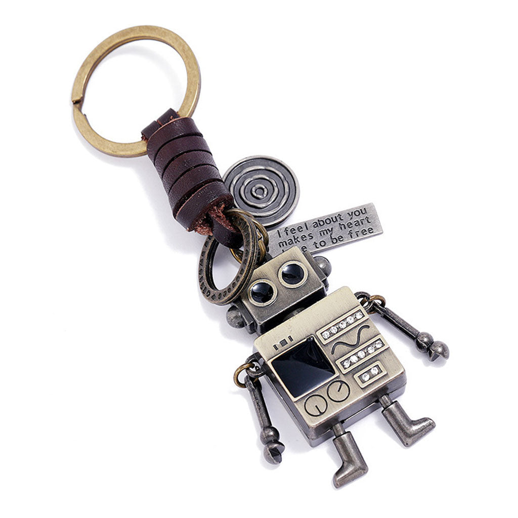 Close-up of a retro robot keychain, showing its movable arms, braided leather cord, and inspirational engraved tags.